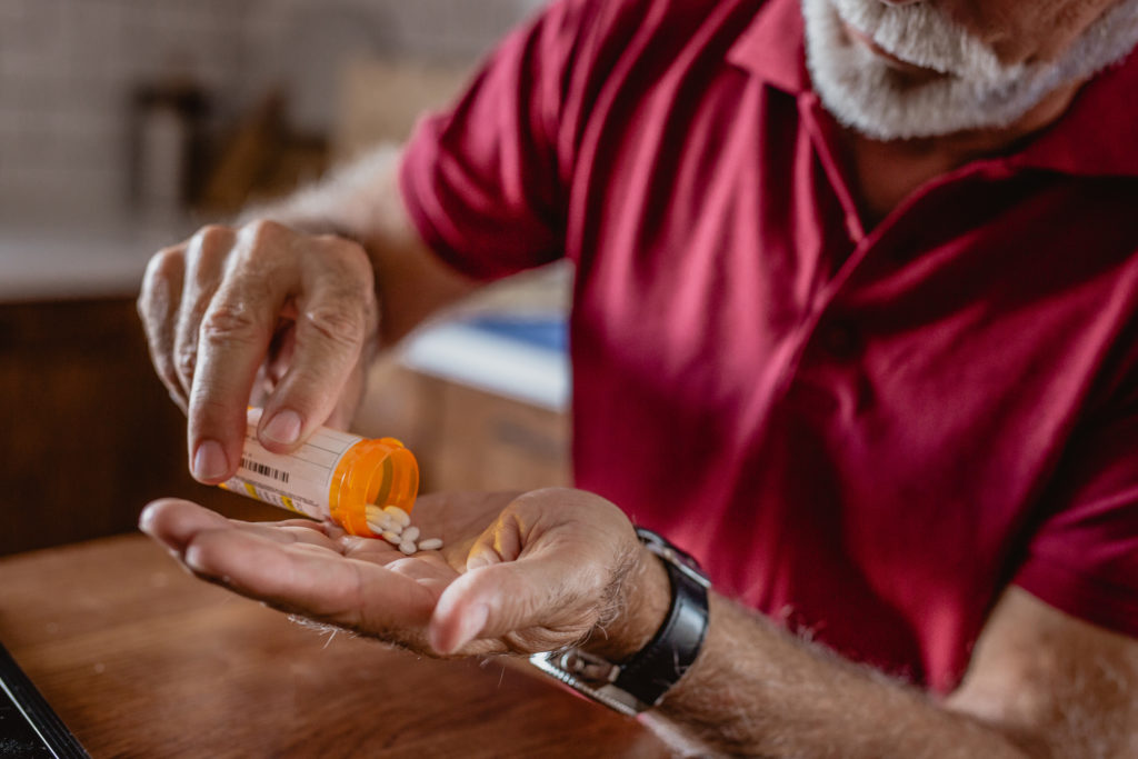 Elderly male preparing medication